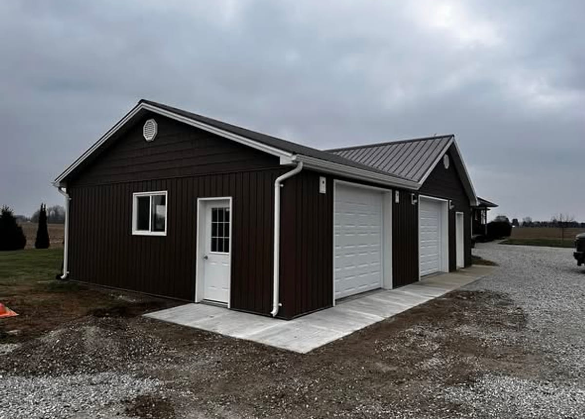 A post-frame farm building with dark steel cladding